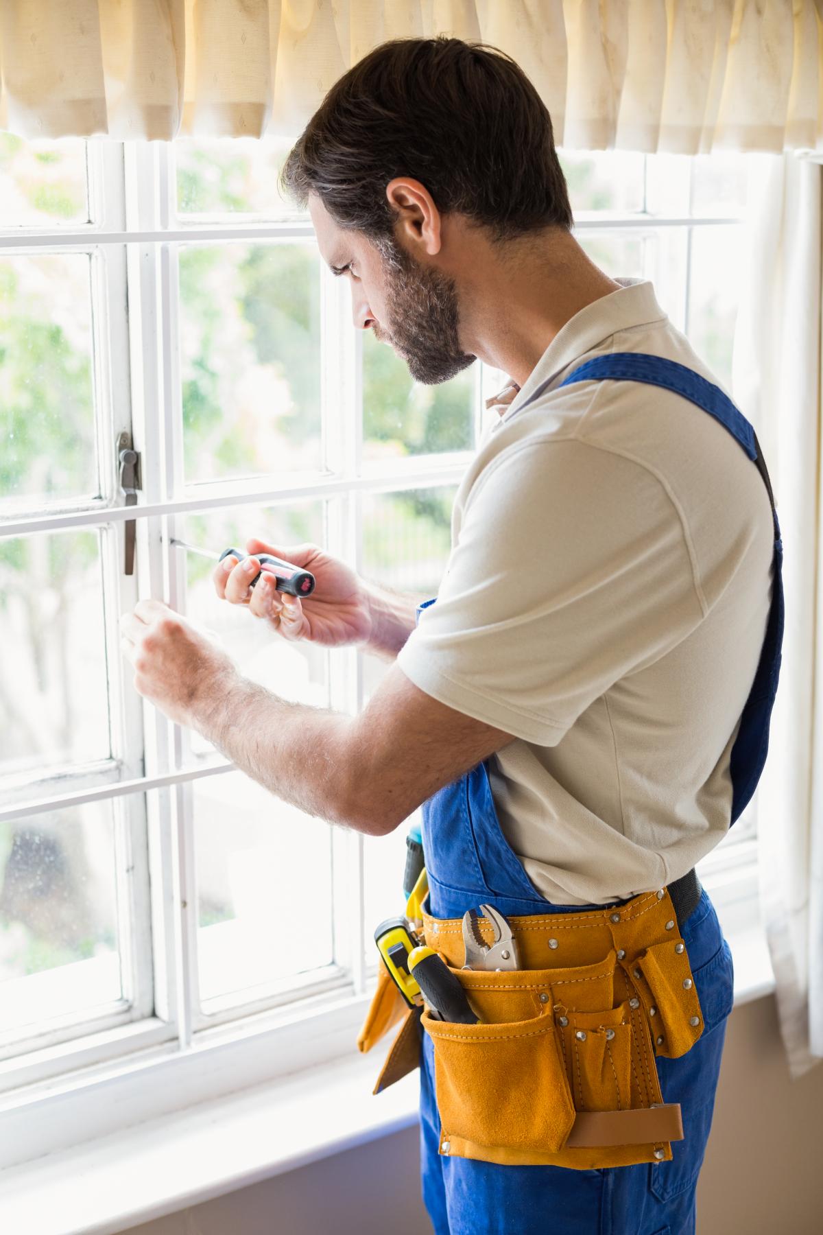 Handyman fixing a window in a new house